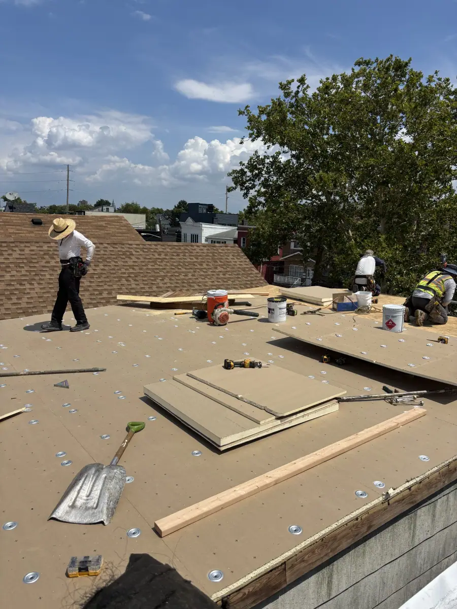 Insulation board being laid across a flat roof before the membrane goes on
