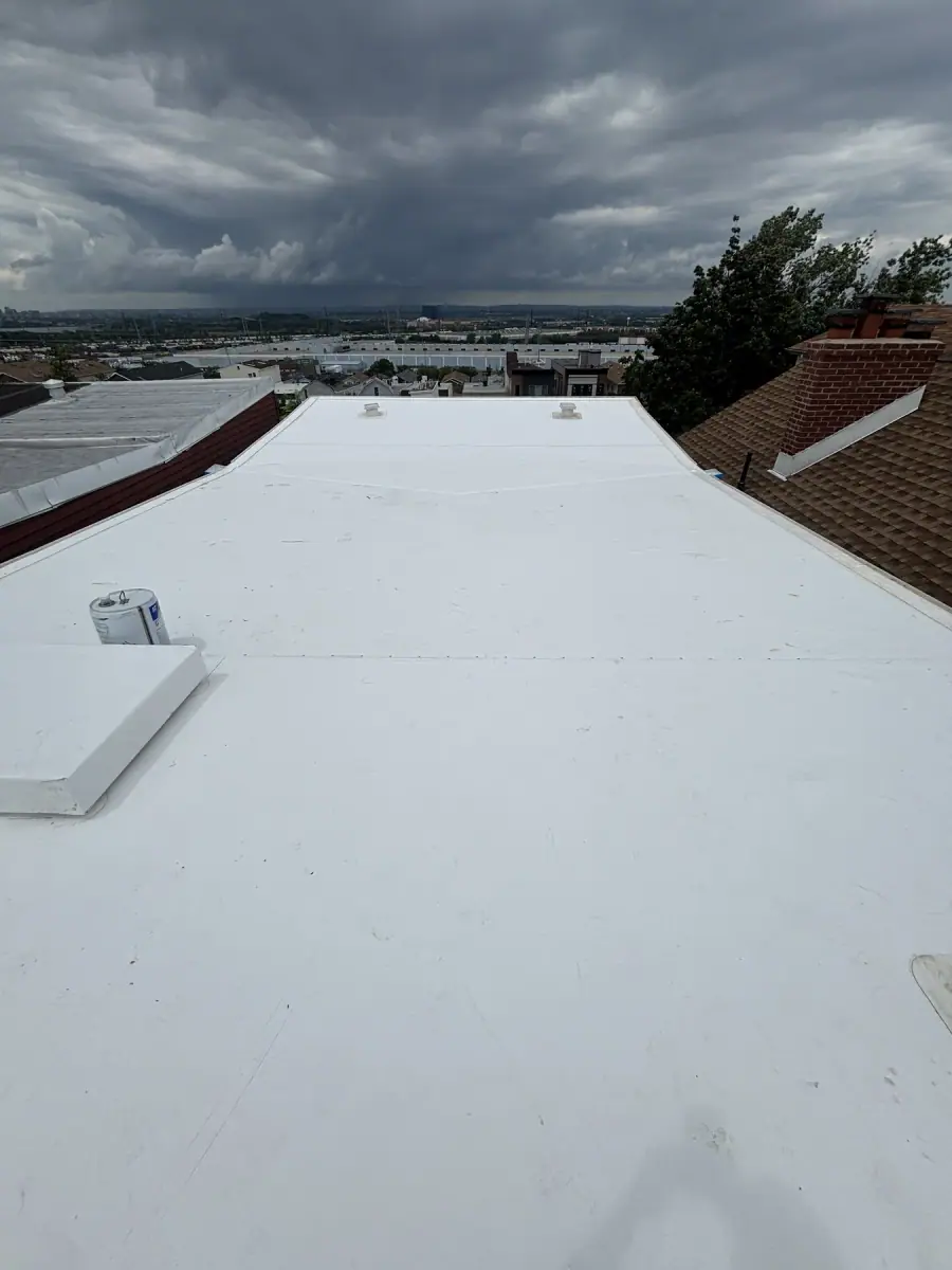 A white flat roof membrane finished between two brick parapet walls