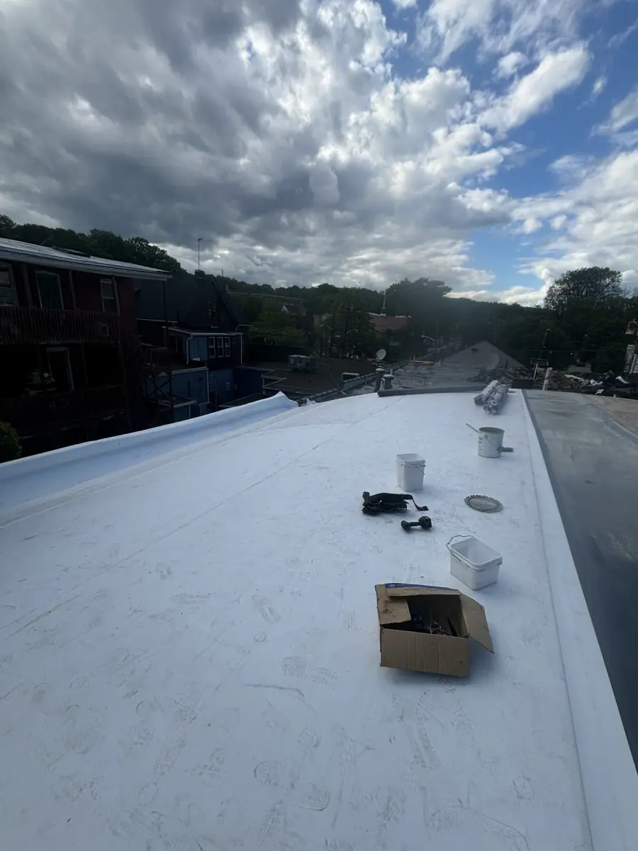 A finished flat roof in white membrane with vent pipes standing up through it