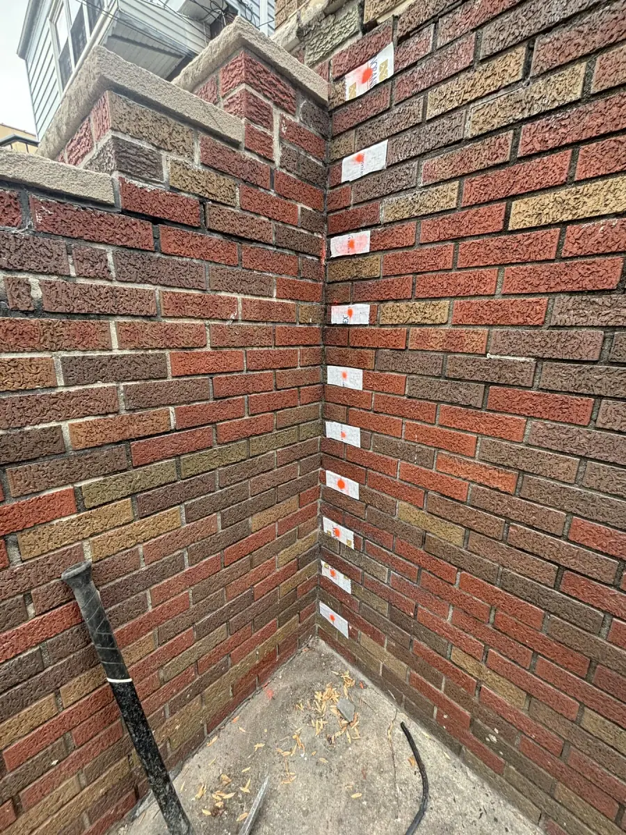 The corner of a brick wall being repointed, spacers set in the fresh joints