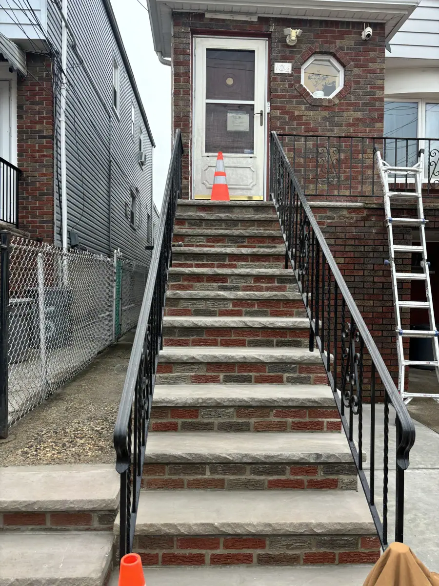 A long flight of brick steps with iron railings either side leading up to a front door