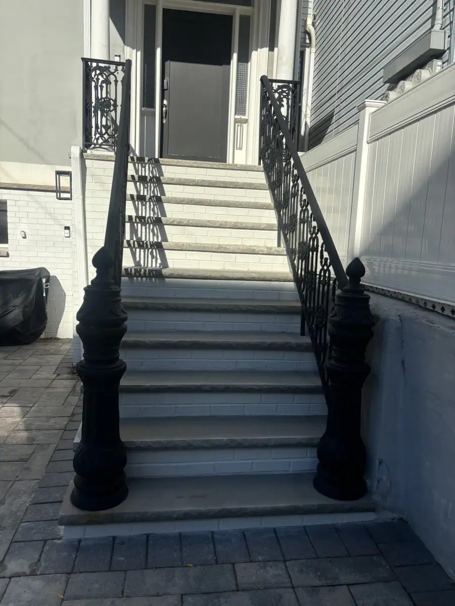 Rebuilt front steps finished and painted, with the original ornate iron newel posts kept