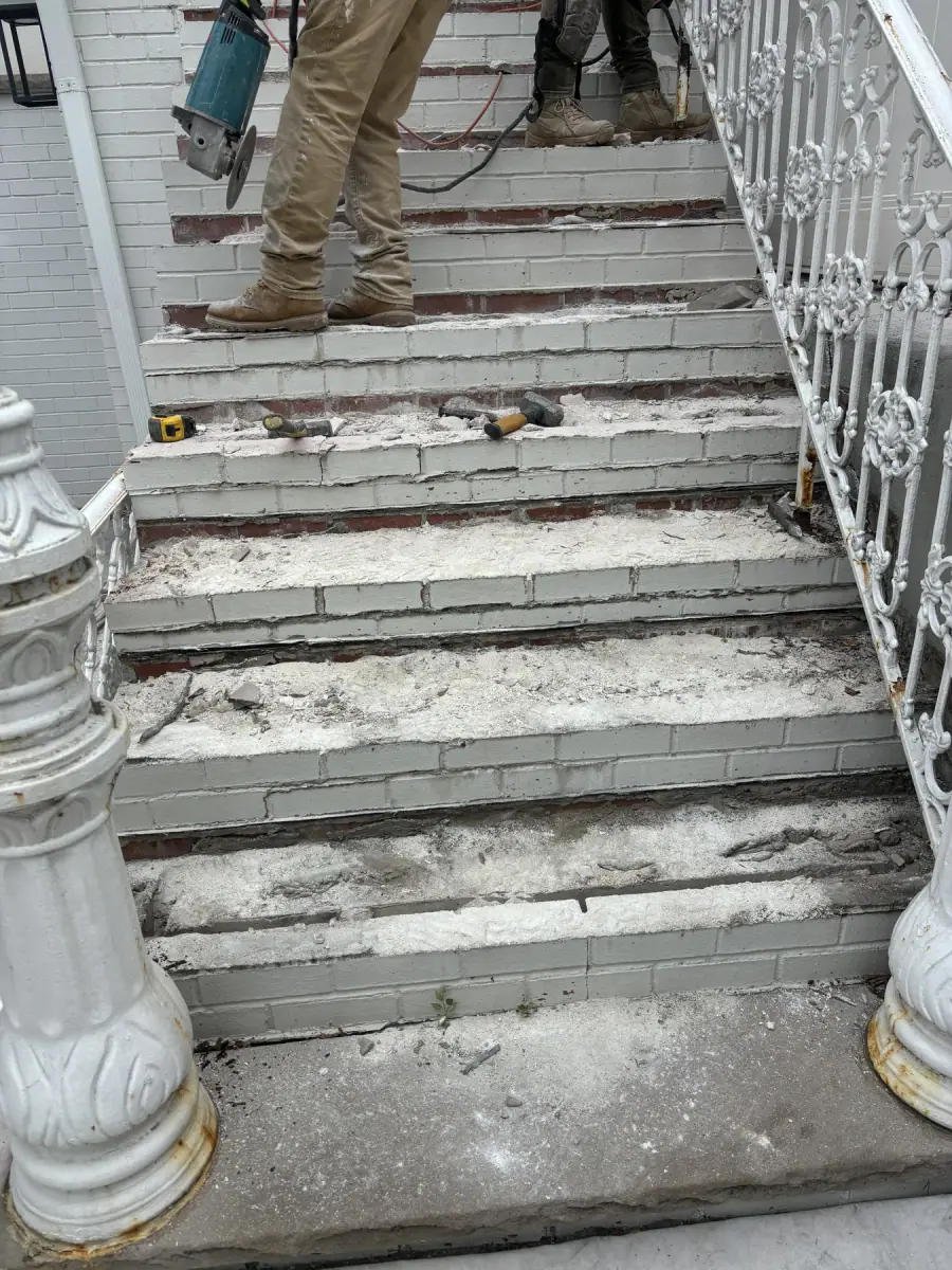 Old front steps stripped back with the treads lifted off, ready to rebuild