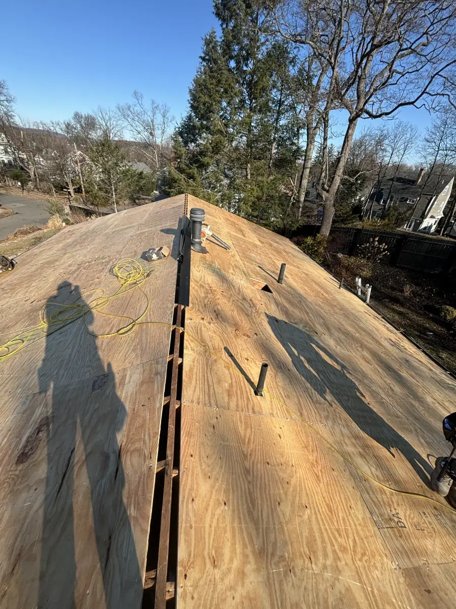 A new plywood roof deck with the slot for a ridge vent cut along the peak