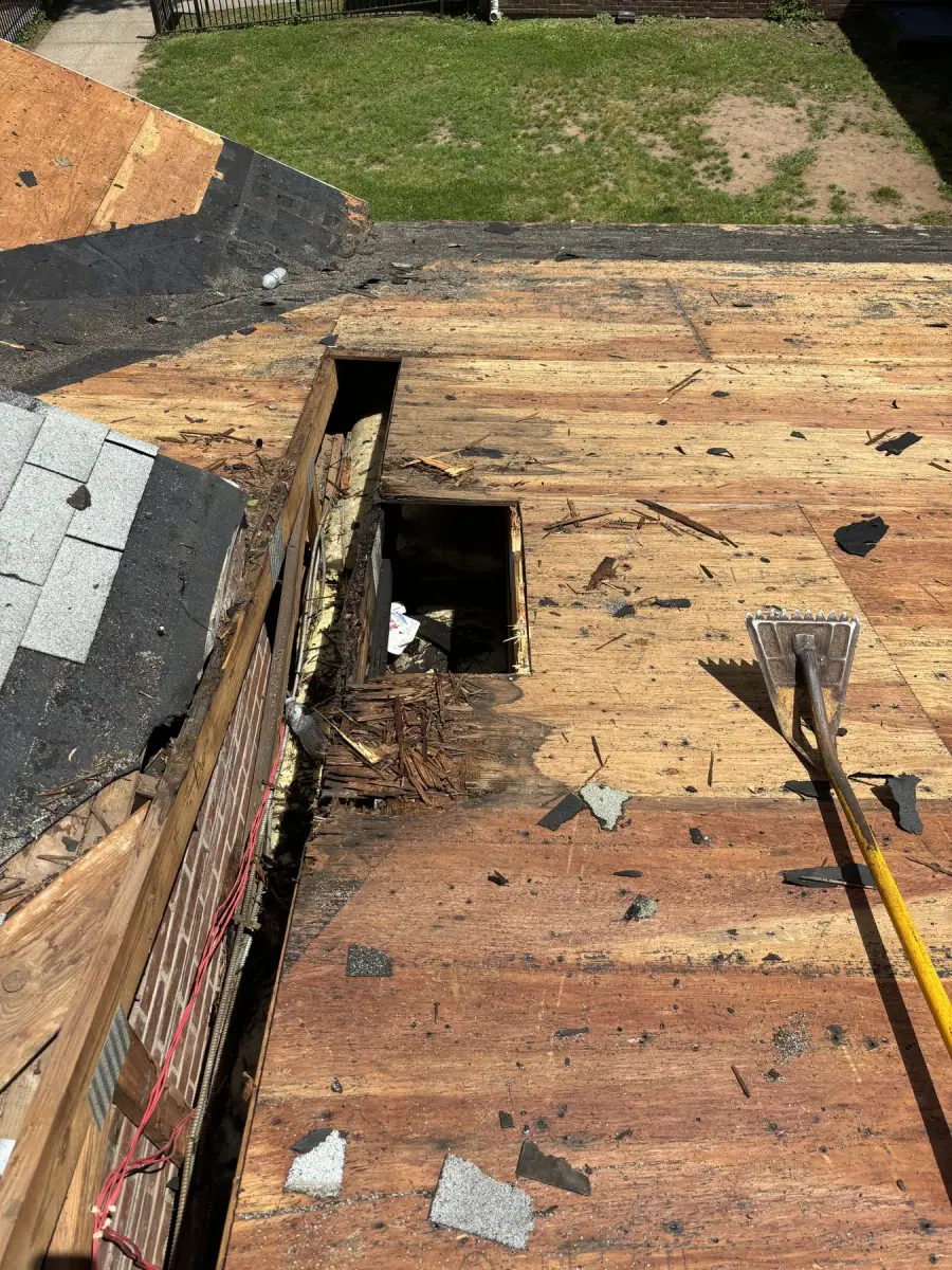 A hole rotted clean through a roof deck, exposed once the old shingles came off