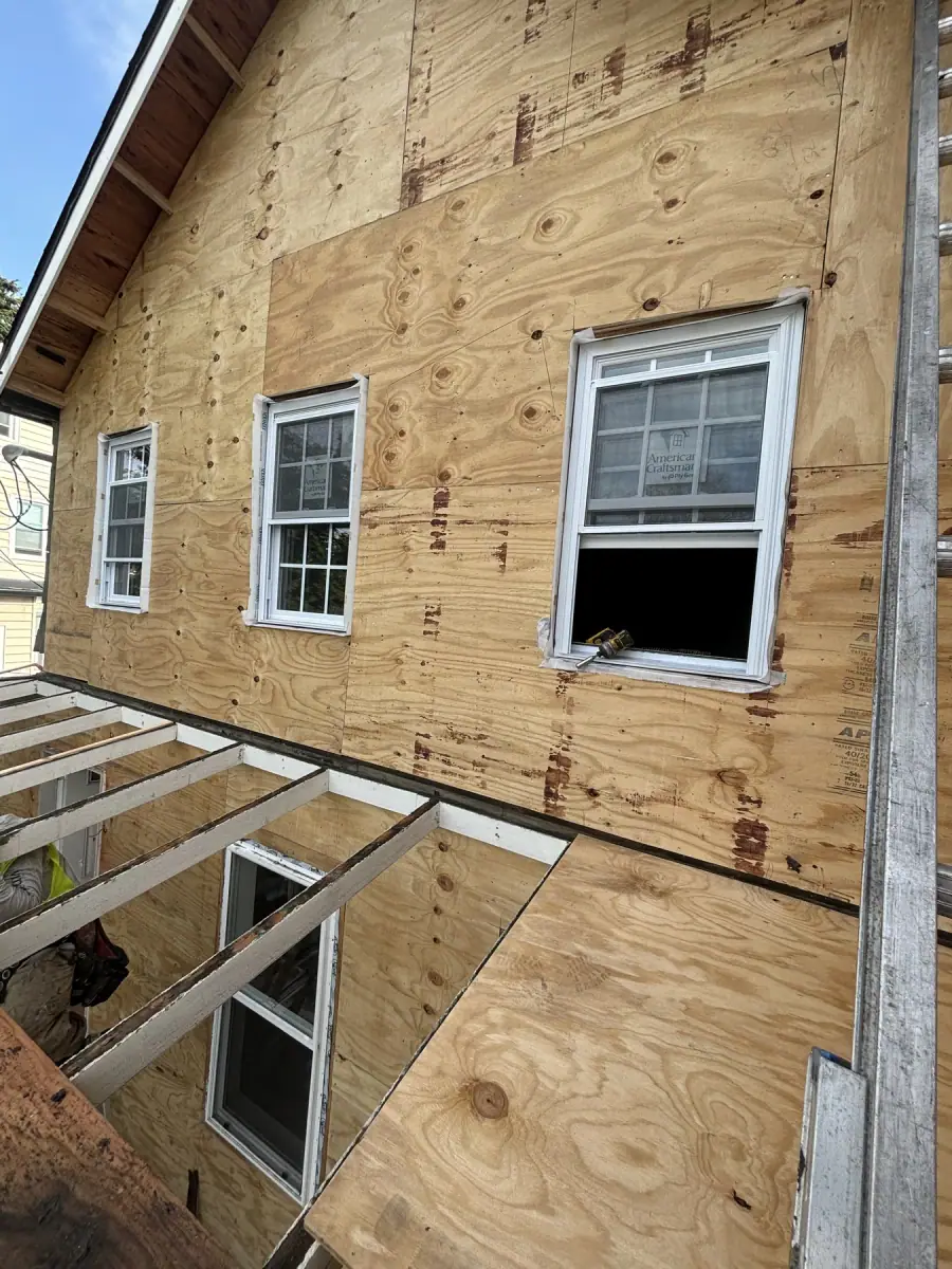 A house wall re sheathed in new plywood with the windows set back in