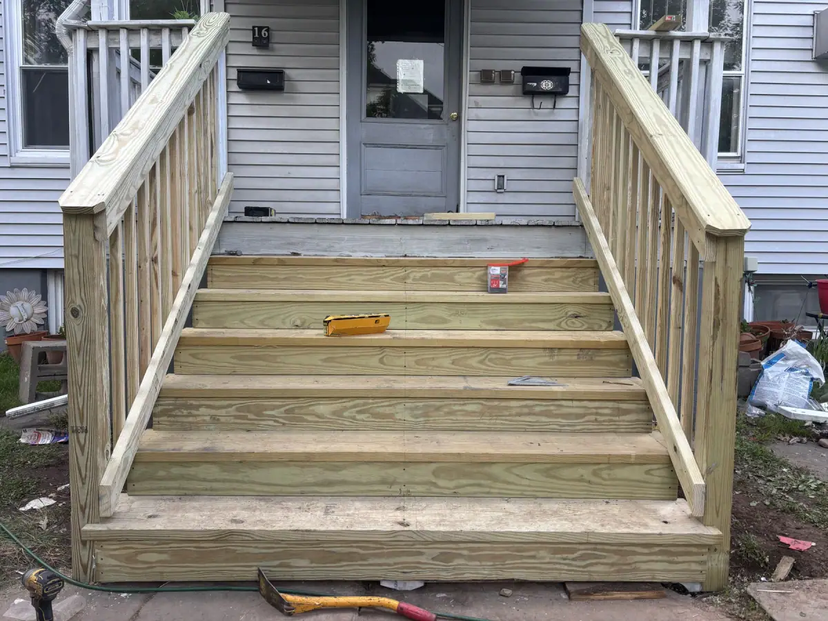 Finished timber steps with handrails either side leading up to a door